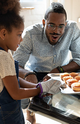 Father and daughter baking muffins