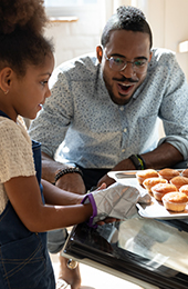 Father and daughter baking muffins