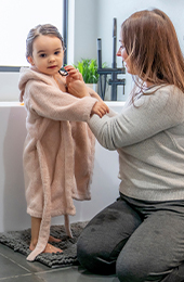 Mother drying daughter after bath